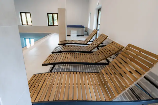 Zonă de relaxare cu șezlonguri lângă piscină și jacuzzi